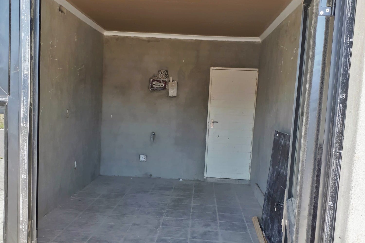 Bare grey plaster room in a Gordon's Bay house before any sealer or paint