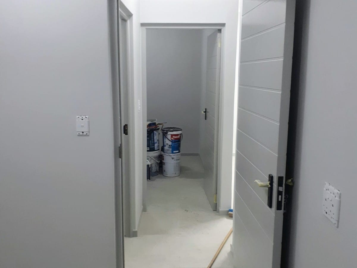 Painted corridor and doorways in a Gordon's Bay house, finished from bare plaster, paint tins still in the room