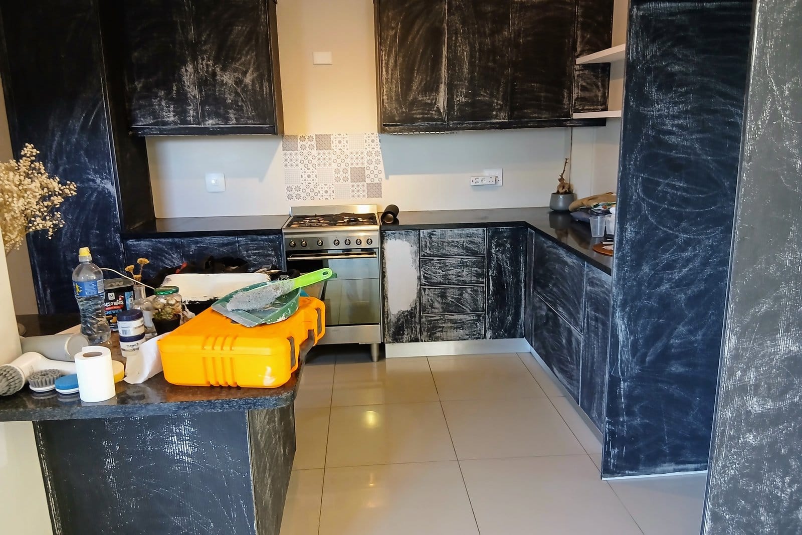 The same cupboards sanded back, abrasion marks and dust across every door