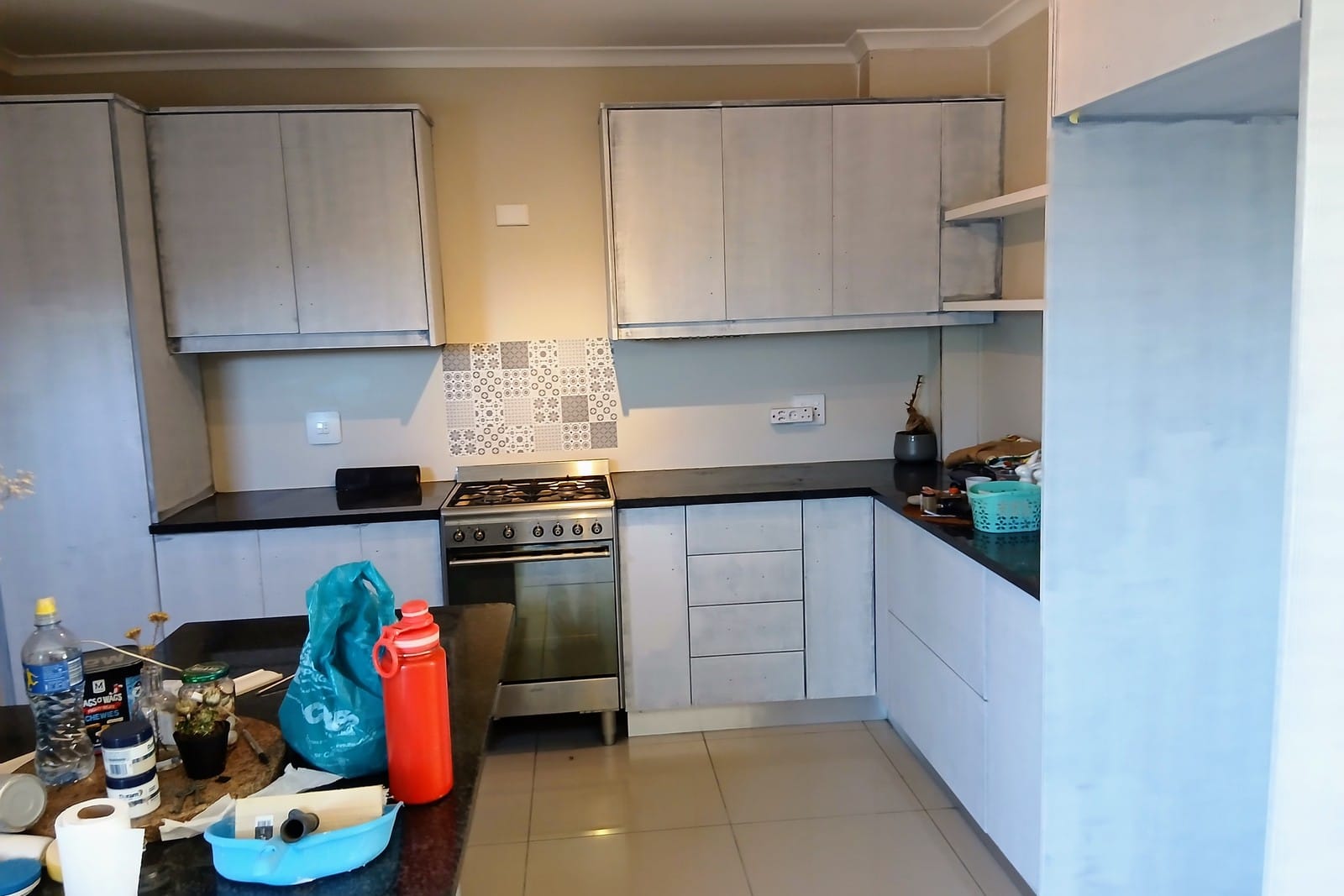 The same kitchen in a pale grey undercoat, every door and panel covered