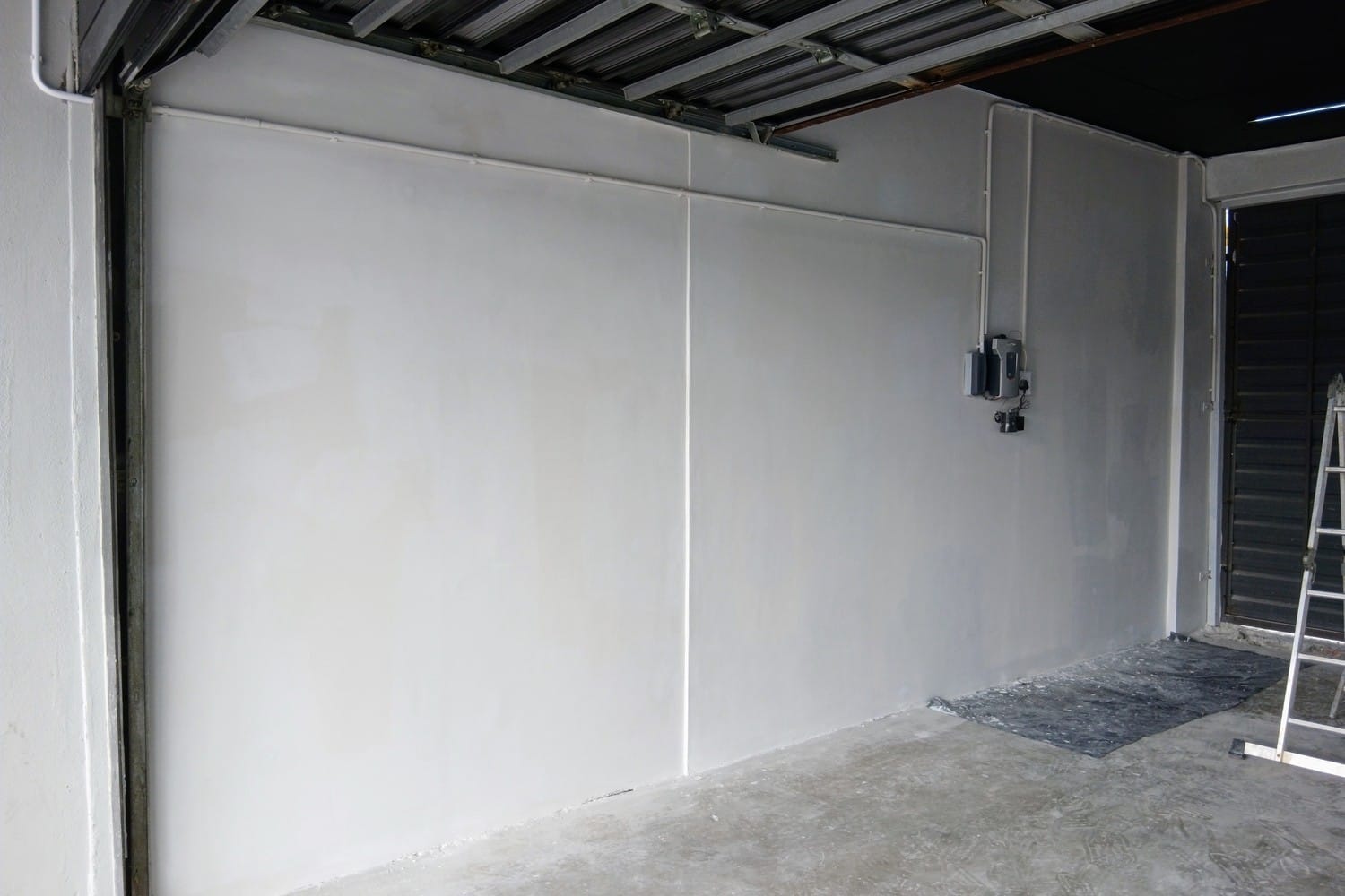 The same Strand garage wall skimmed, primed and carrying its first coat